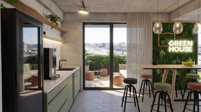 Moderner Aufenthaltsraum im Greenhouse Senden mit Küchenzeile, Bartheke, Moosbildwand mit leuchtendem „Green House"-Schriftzug und Zugang zur Terrasse.